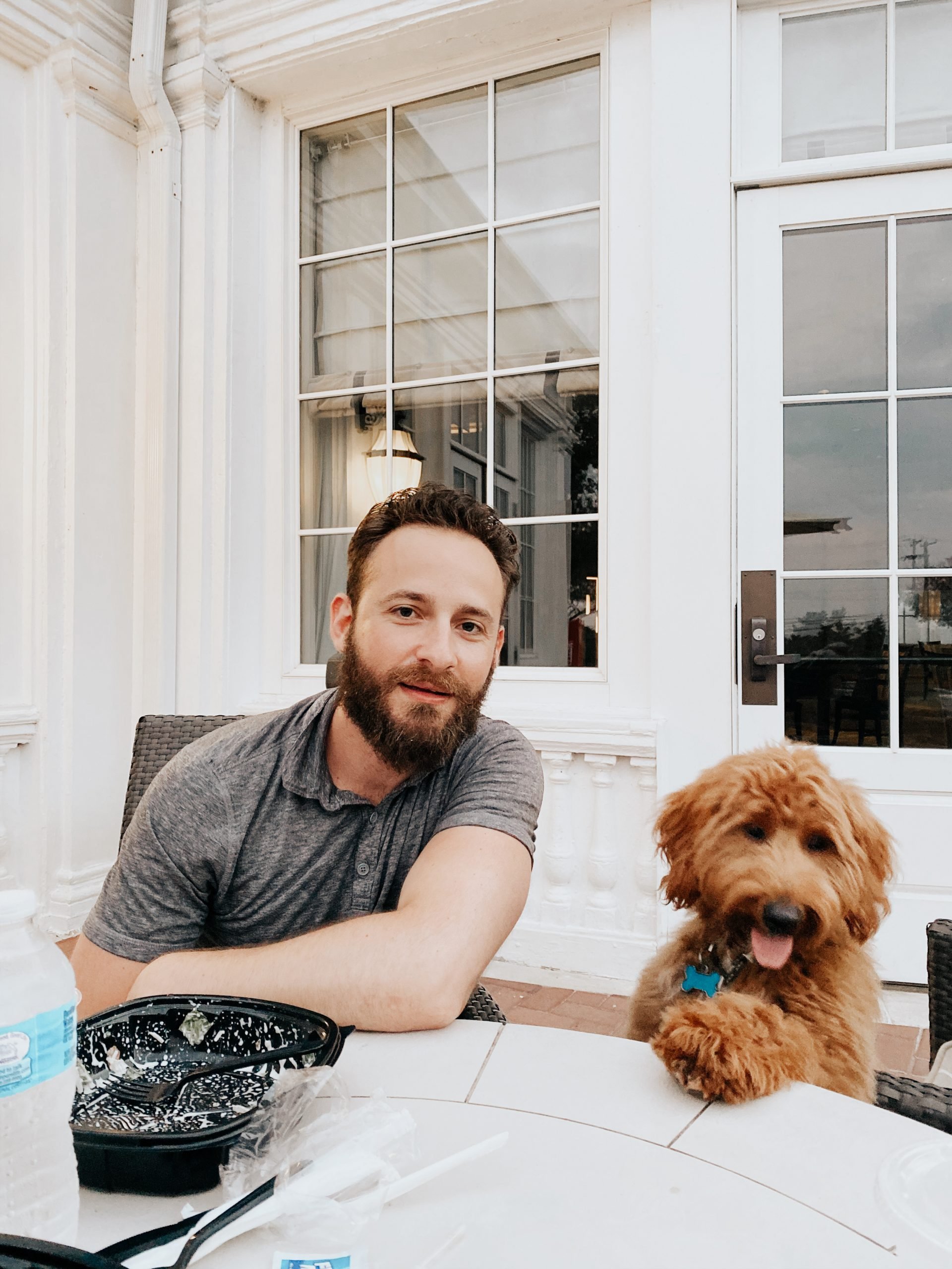 a man with a beard and a dog sitting at a table